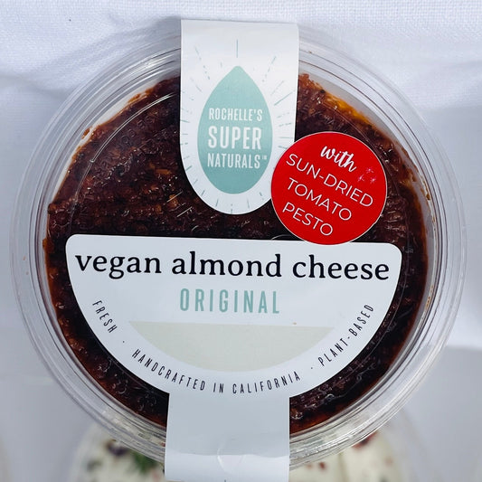 Assorted vegan almond cheese containers on a white background